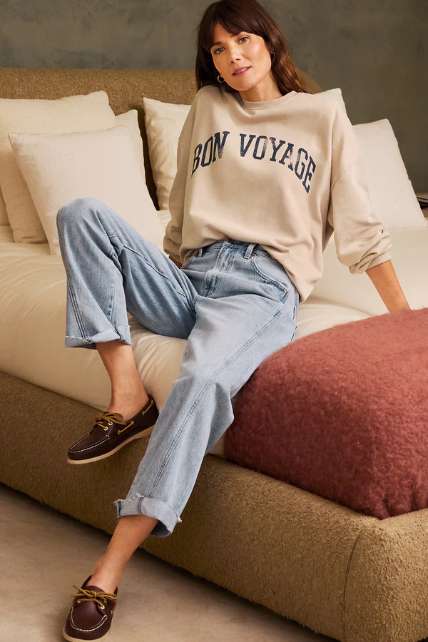 Expert jean fitting in action: our denim expertise shows how to find the perfect jeans with a relaxed-fit boyfriend style, paired with a cream 'Bon Voyage' sweatshirt