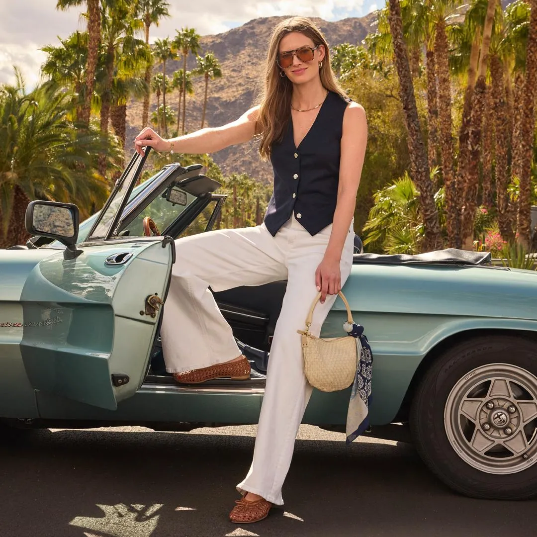 ways to wear white jeans: A woman in a red and white striped shirt and white denim shorts, showing a casual summer outfit with white shorts as an alternative to white jeans.