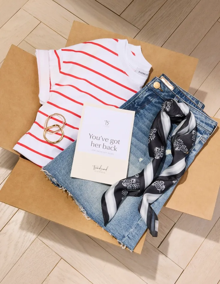 A curated wardrobe subscription reveal: Trendsend stylist's personalized selection including striped tee, jeans, scarf, and jewelry with a personal styling note